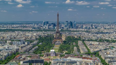 Téléchargez les photos : Vue aérienne depuis la tour Montparnasse avec tour Eiffel et gratte-ciel du quartier de la Défense sur fond timelapse à Paris, France. Vue de dessus de la terrasse d'observation à la journée ensoleillée d'été. - en image libre de droit