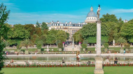 Foto de La hermosa vista de los Jardines de Luxemburgo timelapse con fuente en París, Francia. Cúpula panteón sobre fondo. Cielo azul nublado en el día de verano. - Imagen libre de derechos
