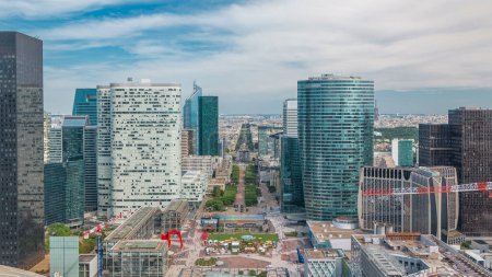 Photo for Aerial view of Paris to triumphal arch and modern towers timelapse from the top of the skyscrapers in Paris business district La Defense. Sunny summer day with blue cloudy sky. Paris, France - Royalty Free Image