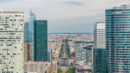 Photo for Aerial view of Paris and modern towers timelapse from the top of the skyscrapers in Paris business district La Defense. Traffic on avenue to triumphal arch. Sunny summer day. Paris, France - Royalty Free Image