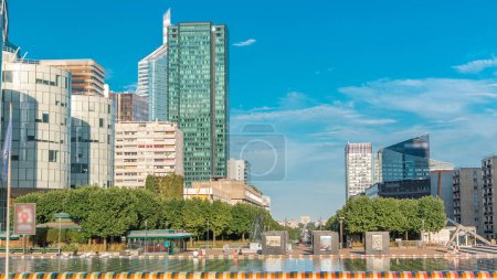 Photo for Skyscrapers of La Defense with fountain timelapse - Modern business and residential area in Paris, France. Arc de Triomphe with Champs Elysees on background. Blue cloudy sky at sunny summer day - Royalty Free Image