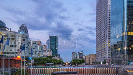 Photo for Paris cityscape with modern buildings in business district La Defense day to night transition timelapse. Glass facade skyscrapers. Arc de Triomphe with Champs Elysees on background. Paris, France - Royalty Free Image