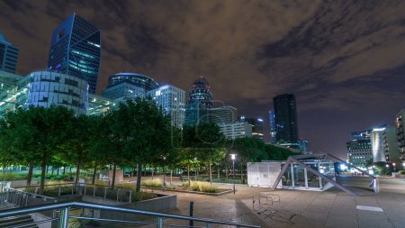 Photo for Paris cityscape with illuminated modern buildings in business district La Defense timelapse hyperlapse by night. Glass facade skyscrapers. Concept of economics, finances. Paris, France - Royalty Free Image