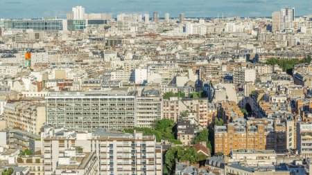 Téléchargez les photos : Panorama aérien au-dessus des toits des maisons dans un timelapse de Paris. Vue du soir avec bâtiments résidentiels avant le coucher du soleil - en image libre de droit