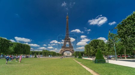 Foto de Torre Eiffel en los Campos de Marte en París timelapse hyperlapse, Francia. Cielo nublado azul en el día de verano con césped verde y gente caminando y relajarse - Imagen libre de derechos