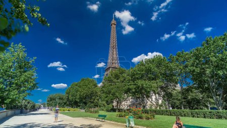 Téléchargez les photos : Tour Eiffel depuis le front de mer de la rivière Siene à Paris timelapse hyperlapse, France. Ciel bleu nuageux le jour d'été avec des arbres verts et des gens qui se promènent - en image libre de droit