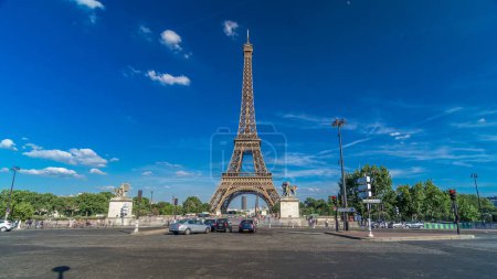 Foto de Torre Eiffel con tráfico en un puente sobre el río Siene en Paris timelapse hyperlapse, Francia. Cielo azul nublado en el día de verano con árboles verdes y tráfico de coches en la intersección - Imagen libre de derechos
