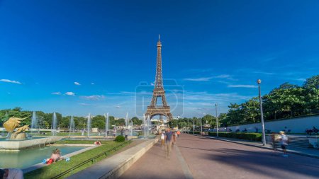 Photo for Evening view of Eiffel Tower timelapse hyperlapse with fountain in Jardins du Trocadero in Paris, France. Long shadows. People walking around. Eiffel Tower is one of the most iconic landmarks of Paris - Royalty Free Image
