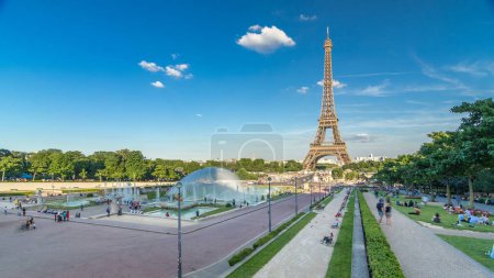 Photo for Sunset view of Eiffel Tower timelapse with fountain in Jardins du Trocadero in Paris, France. Long shadows. People walking around. Eiffel Tower is one of the most iconic landmarks - Royalty Free Image