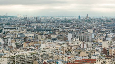 Téléchargez les photos : Panorama aérien au-dessus des maisons sur les toits dans un timelapse parisien. Vue de dessus avec principaux points d'intérêt le matin avec ciel nuageux - en image libre de droit