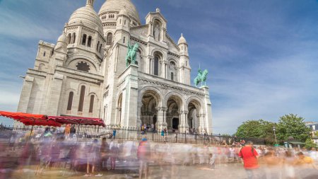 Photo for Tourists near the Basilica of the Sacred Heart of Paris (Sacra-Coeur) is a Roman Catholic church timelapse hyperlapse. Side view. Located at the summit of the butte Montmartre. Paris, France. - Royalty Free Image