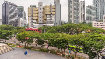 Téléchargez les photos : Vue aérienne des gratte-ciel près de la route Orchard à Singapour timelapse. Arbres et circulation dans la rue. Orchard road est l'un des meilleurs quartiers commerçants de Singapour
. - en image libre de droit