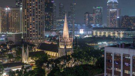 Foto de Cronograma nocturno aéreo de la Catedral de San Andrés. Es una catedral anglicana en Singapur, la catedral más grande del país. Rascacielos sobre fondo - Imagen libre de derechos