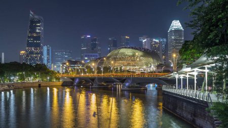 Photo for Illuminated Double Esplanade Theatres domes behind Esplanade Drive with traffic night timelapse hyperlapse. Singapore skyscrapers skyline on a background - Royalty Free Image