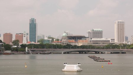 Photo for Singapore Merlion Park and Victoria Concert Hall with National Art Gallery, esplanade bridge timelapse. Reflections in water of marina bay - Royalty Free Image
