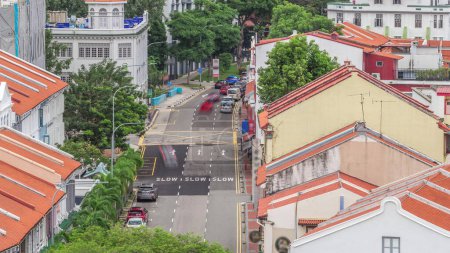 Photo for Aerial view of art deco shophouses with red roofs along Neil road in Chinatown area timelapse. Traffic on the street with intersection - Royalty Free Image