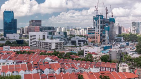 Foto de Vista aérea de Chinatown con techos rojos y rascacielos del Distrito Central de Negocios timelapse, Singapur. Contraste entre edificios antiguos y modernos. Sitio de construcción y tráfico en las calles - Imagen libre de derechos