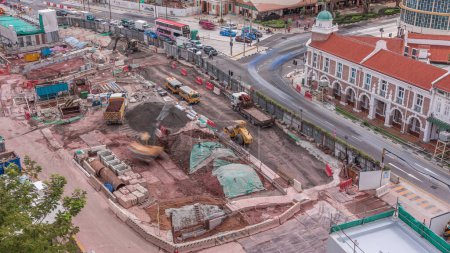 Foto de Un gran sitio de construcción en el timelapse de la ciudad, el proceso de construcción masiva buliding con vehículo pesado en el trabajo, excavadora y excavadora, Singapur - Imagen libre de derechos
