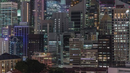 Téléchargez les photos : Paysage urbain aérien du centre-ville de Singapour d'architecture moderne avec des gratte-ciel éclairés nuit timelapse, vue d'en haut dans le quartier Chinatown avec de nombreuses fenêtres éclatantes dans les tours - en image libre de droit