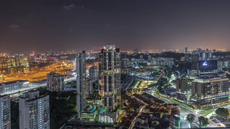 Téléchargez les photos : Skyline de la ville avec port commercial de Singapour timelapse de nuit. Vue panoramique du port de fret asiatique le plus achalandé avec des centaines de navires chargeant des marchandises d'exportation et d'importation et des milliers de conteneurs dans le port - en image libre de droit