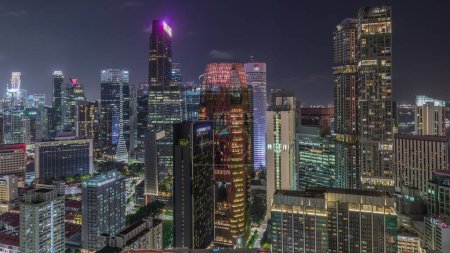 Téléchargez les photos : Paysage urbain aérien du centre-ville de Singapour d'architecture moderne avec des gratte-ciel éclairés timelapse nocturne, vue d'en haut du belvédère avec des fenêtres éclatantes dans les tours - en image libre de droit