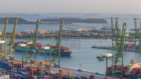 Photo for Commercial port of Singapore aerial timelapse. Ship make a turn. Bird eye view of busiest Asian cargo port with hundreds of ships loading export and import goods and thousands of containers in harbor - Royalty Free Image