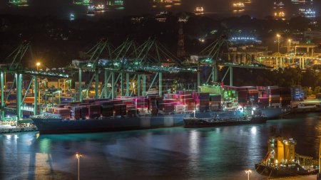 Téléchargez les photos : Port commercial de Singapour timelapse de nuit. Vue panoramique du port de fret asiatique le plus achalandé avec le navire déchargeant des marchandises d'exportation et d'importation et des milliers de conteneurs dans le port - en image libre de droit