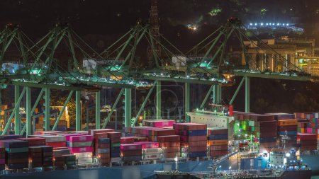 Photo for Commercial port of Singapore night timelapse. Close up view of busiest Asian cargo port with ship unloading export and import goods and thousands of containers in harbor - Royalty Free Image