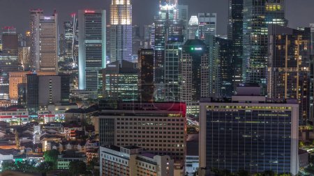 Téléchargez les photos : Paysage urbain aérien du centre-ville de Singapour d'architecture moderne avec des gratte-ciel éclairés timelapse nocturne, vue d'en haut du belvédère avec des fenêtres éclatantes dans les tours - en image libre de droit