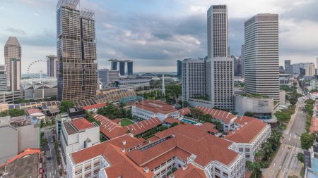 Photo for Evening panorama with Marina Bay area and skyscrapers city skyline aerial timelapse. The tower shape building at the North bridge road with traffic in Singapore. - Royalty Free Image