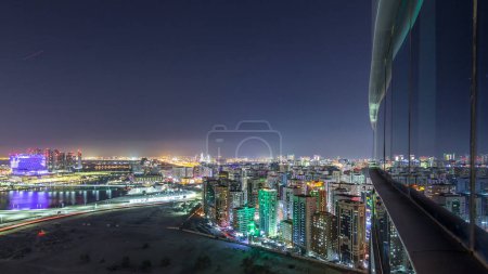 Foto de Skyline aéreo del centro de la ciudad de Abu Dhabi desde arriba timelapse noche con rascacielos iluminados con reflexión sobre la superficie de vidrio - Imagen libre de derechos