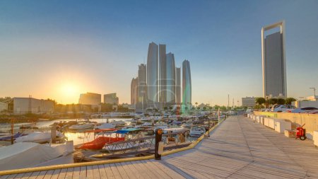 Téléchargez les photos : Al Bateen marina Abu Dhabi au coucher du soleil timelapse avec des bateaux et des gratte-ciel modernes sur fond - en image libre de droit