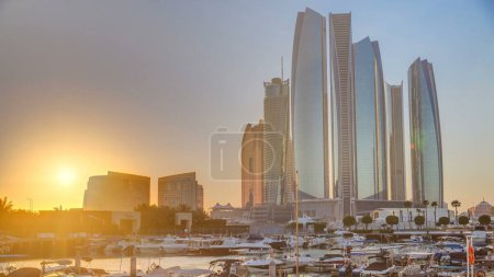 Téléchargez les photos : Al Bateen marina Abu Dhabi au coucher du soleil timelapse avec des bateaux et des gratte-ciel modernes sur fond - en image libre de droit