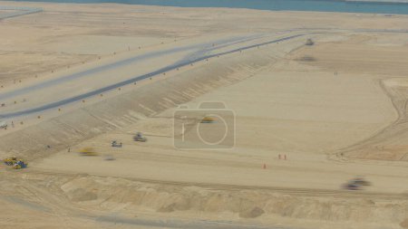 Téléchargez les photos : Compacteur de sol et bulldozer pendant les travaux de construction routière timelapse. Vue aérienne d'en haut. Abu Dhabi, Émirats arabes unis - en image libre de droit