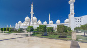Sheikh Zayed Grand Mosque timelapse hyperlapse in Abu Dhabi, the capital city of United Arab Emirates. Side view with domes and minarets. Trees on foreground. Blue sky at sunny day puzzle #707666644