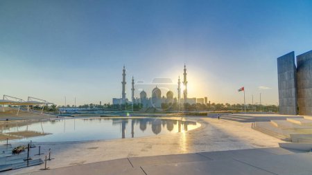 Téléchargez les photos : Grande mosquée Cheikh Zayed à Abu Dhabi au coucher du soleil timelapse, EAU. Vue du soir depuis Wahat Al Karama avec réflexions sur l'eau - en image libre de droit