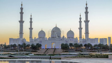 Téléchargez les photos : Grande mosquée Cheikh Zayed à Abu Dhabi période de transition du jour à la nuit après le coucher du soleil, EAU. Vue du soir depuis Wahat Al Karama avec réflexions sur l'eau - en image libre de droit
