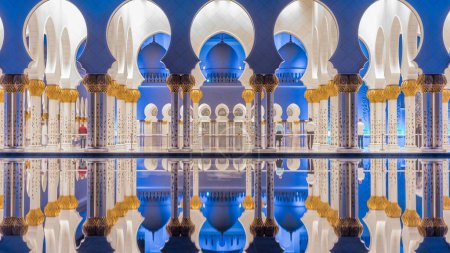 Téléchargez les photos : Grande mosquée Cheikh Zayed illuminée la nuit timelapse, Abu Dhabi, EAU. Vue latérale avec réflexion dans la piscine d'eau. La 3ème plus grande mosquée du monde - en image libre de droit