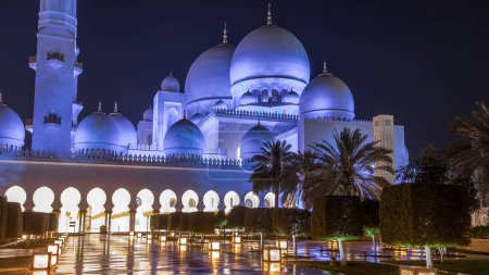 Téléchargez les photos : Grande mosquée Cheikh Zayed illuminée la nuit timelapse, Abu Dhabi, EAU. Vue latérale avec reflets. La 3ème plus grande mosquée du monde - en image libre de droit
