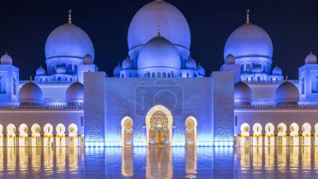 Photo for Sheikh Zayed Grand Mosque illuminated at night timelapse, Abu Dhabi, UAE. Inner court yard with reflections on the floor. The 3rd largest mosque in the world - Royalty Free Image