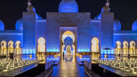 Photo for Sheikh Zayed Grand Mosque illuminated at night timelapse, Abu Dhabi, UAE. Front view with fountains. The 3rd largest mosque in the world - Royalty Free Image