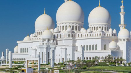 Téléchargez les photos : Timelapse de la Grande Mosquée Cheikh Zayed à Abu Dhabi, la capitale des Émirats arabes unis. Ciel bleu au soleil - en image libre de droit