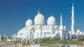 Sheikh Zayed Grand Mosque timelapse in Abu Dhabi, the capital city of United Arab Emirates. Back side with trees and traffic on the road from above. Blue sky at sunny day magic mug #707667122