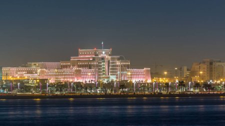 Téléchargez les photos : La ligne d'horizon de Doha avec le ministère de l'Intérieur illuminé la nuit. Vue depuis la corniche. Réflexion dans une eau du Golfe. Doha, Qatar, Moyen-Orient - en image libre de droit
