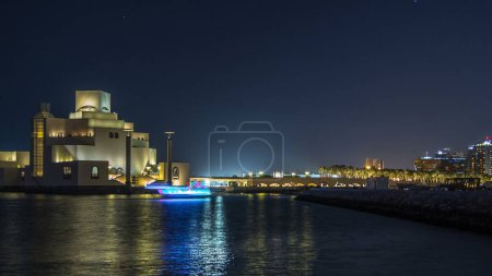Photo for Beautiful Museum of Islamic Art illuminated at night timelapse in Doha, Qatar. Reflection on water of Gulf. It is one of the worlds most complete collections of Islamic artifacts - Royalty Free Image