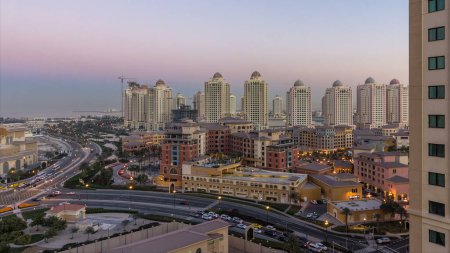 Téléchargez les photos : Soirée au Pearl-Qatar de jour comme de nuit. C'est une île artificielle au Qatar. Trafic sur la route. Vue de la Marina et des bâtiments résidentiels à Porto Arabie à Doha, Qatar, Moyen-Orient - en image libre de droit