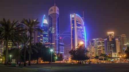 The high-rise district of Doha night timelapse, seen from the Park. Illuminated skyscrapers and palms on west bay mug #707667568