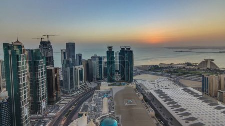 Téléchargez les photos : L'horizon de West Bay et Doha City Center pendant le lever du soleil timelapse, Qatar. gratte-ciel modernes et la circulation sur la route. Golfe sur fond - en image libre de droit