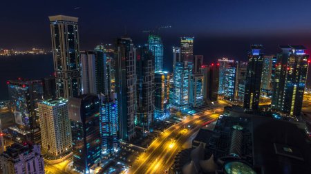 Photo for The skyline of the West Bay area from top in Doha timelapse, Qatar. Illuminated modern skyscrapers aerial view from rooftop at night before sunrise - Royalty Free Image