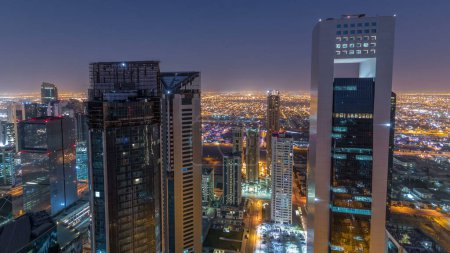 Téléchargez les photos : L'horizon de la région de West Bay depuis le sommet à Doha timelapse, Qatar. gratte-ciel modernes éclairés vue aérienne depuis le toit la nuit avant le lever du soleil - en image libre de droit